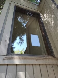 After picture of window covered in dirt and cobwebs.